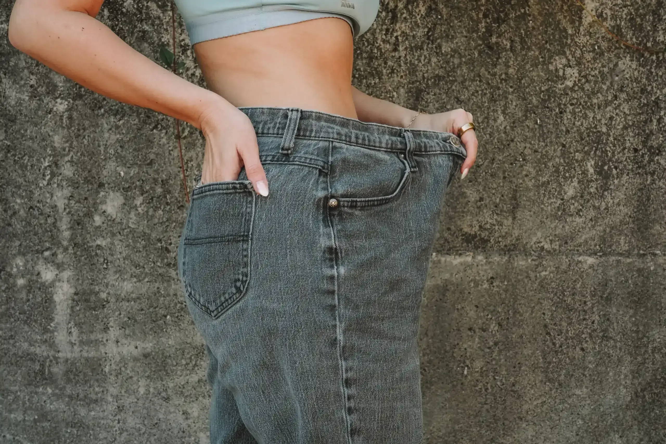 Person evaluating stubborn fat areas at Arise Integrative Wellness Port Charlotte